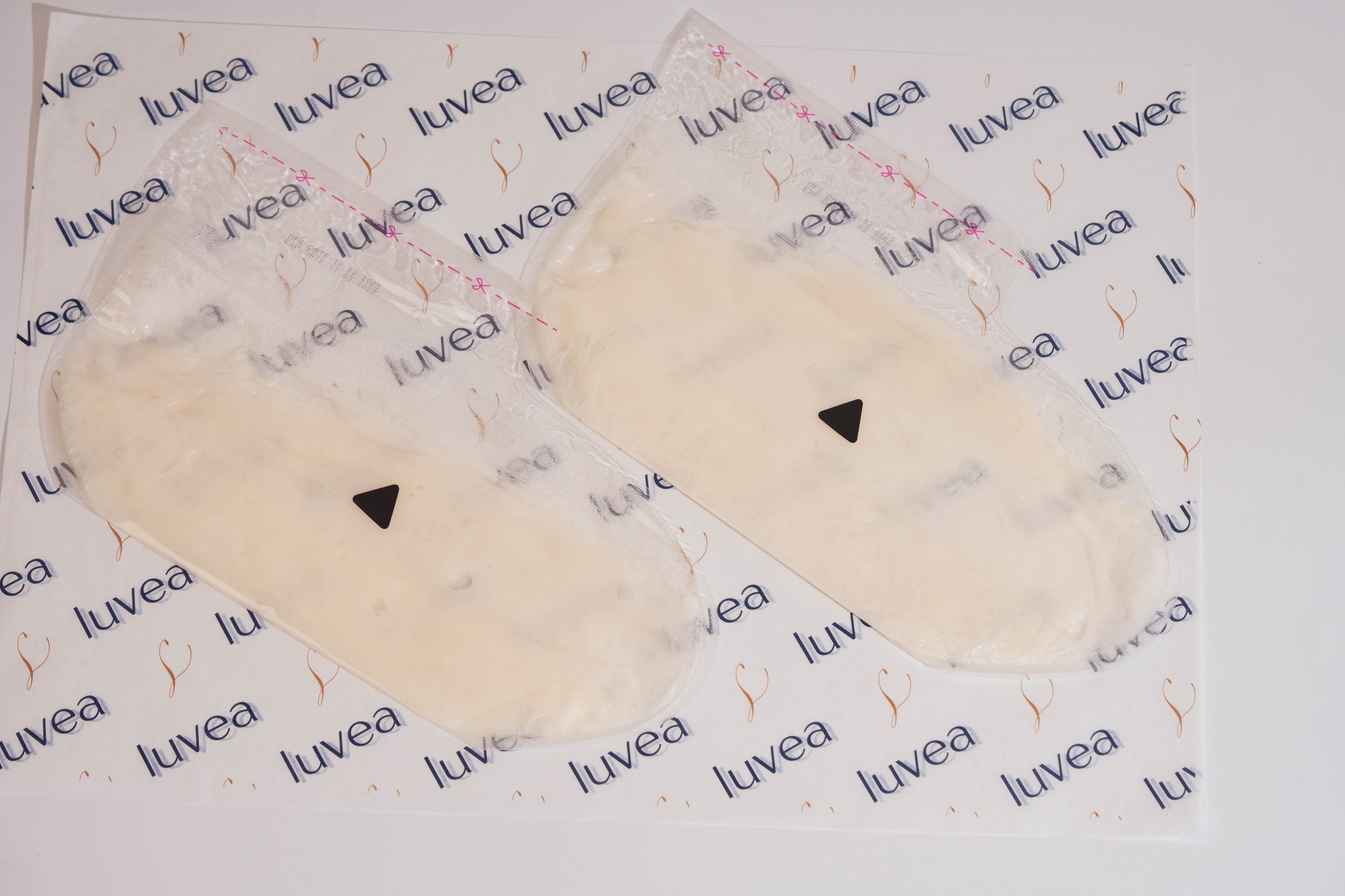 Bootie-shaped paraffin wax masks laid flat on luvéa branded paper