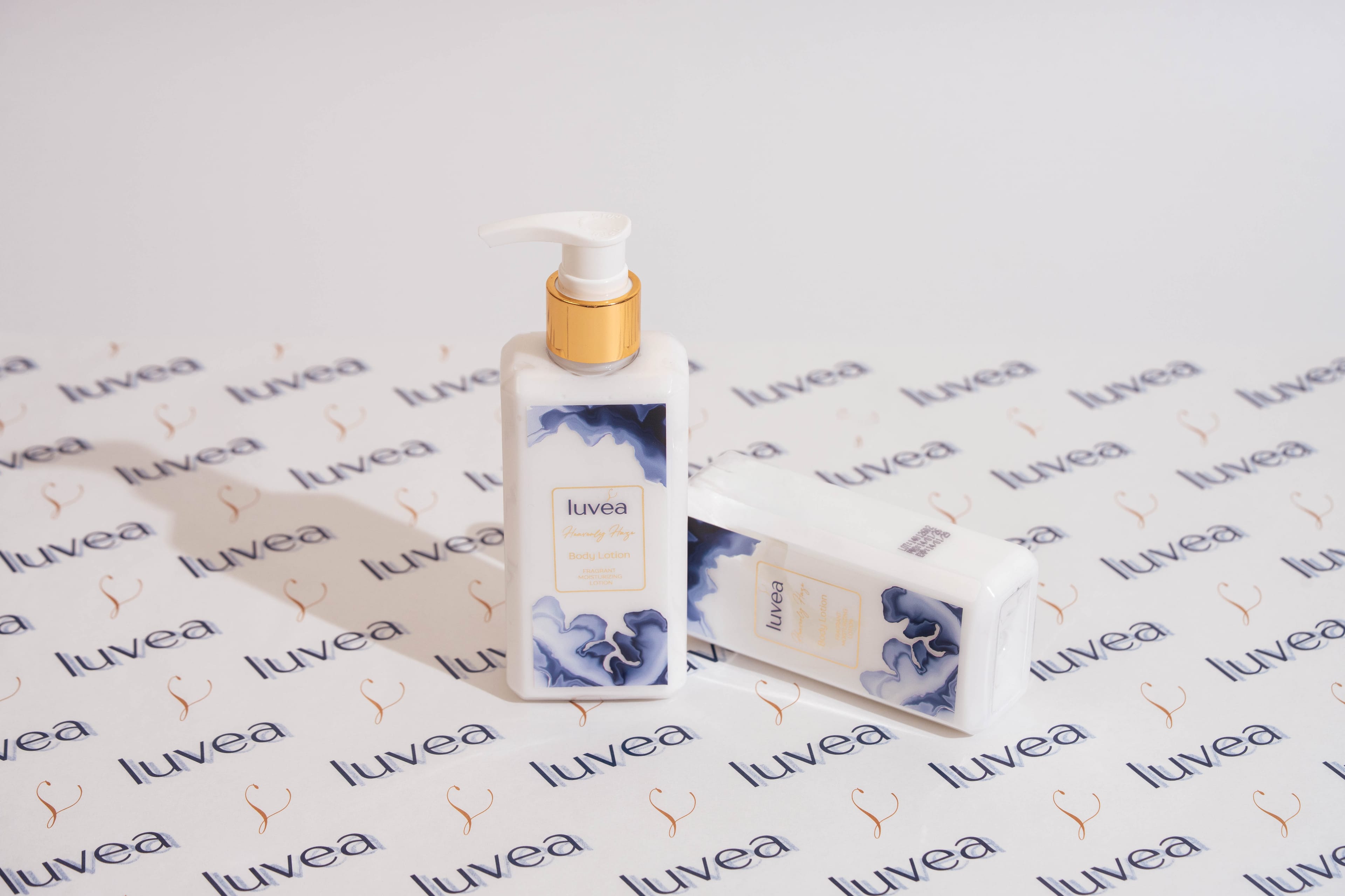 Two Heavenly Haze lotion bottles standing on luvéa-patterned paper